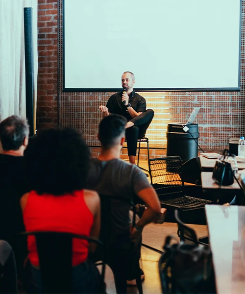 Conférencier animant un séminaire dans un espace événementiel moderne avec des participants attentifs